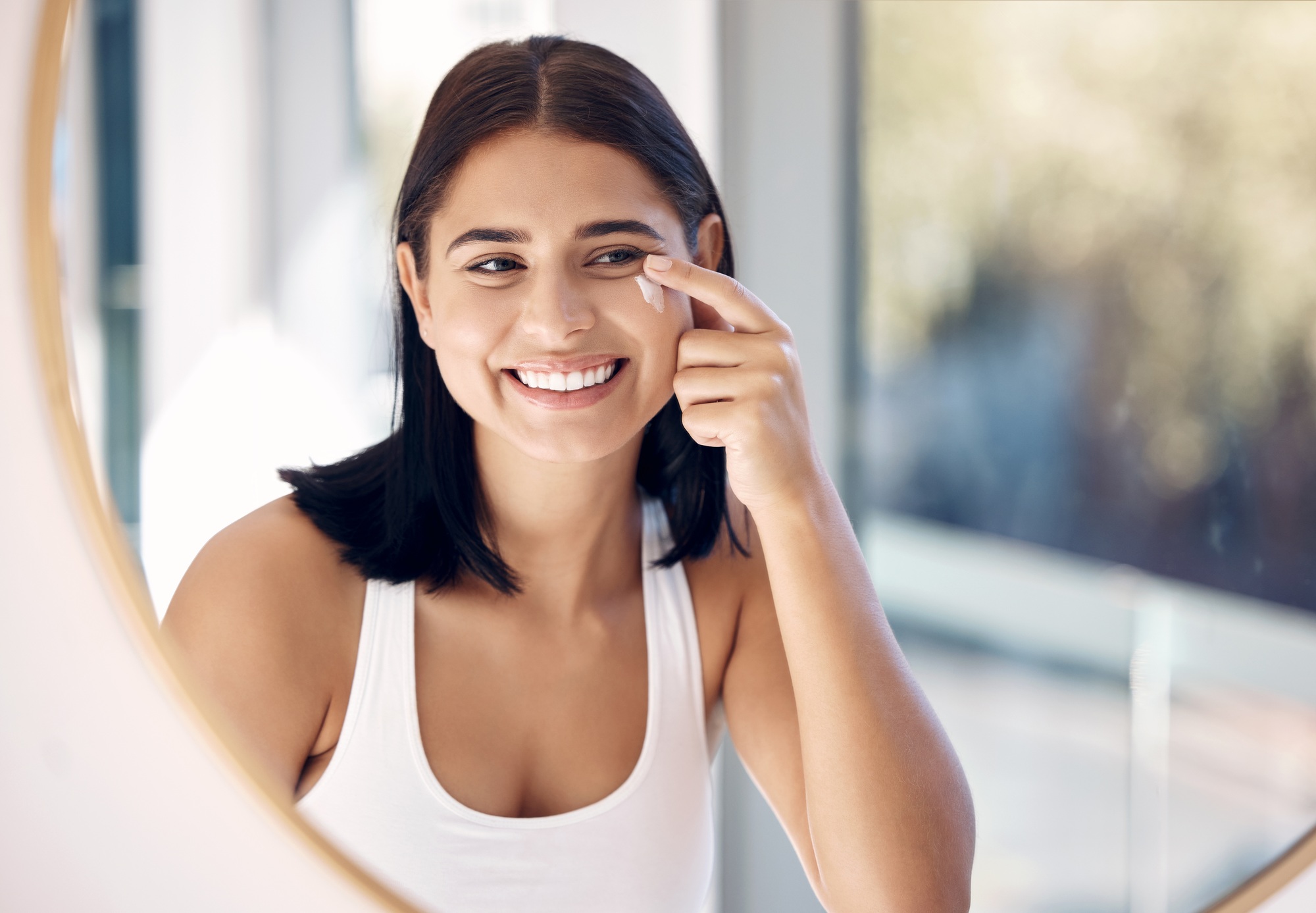 Beauty, cream and skincare woman in mirror for sunscreen, facial and makeup product cleaning in her