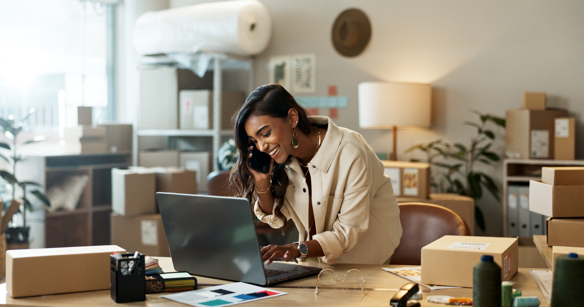 Phone call, small business or happy woman with laptop for ecommerce communication in office. Typing