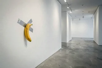 Banane collée au mur d'une galerie d'art contemporain avec du ruban adhésif argenté, œuvre conceptuelle minimaliste dans un espace blanc épuré